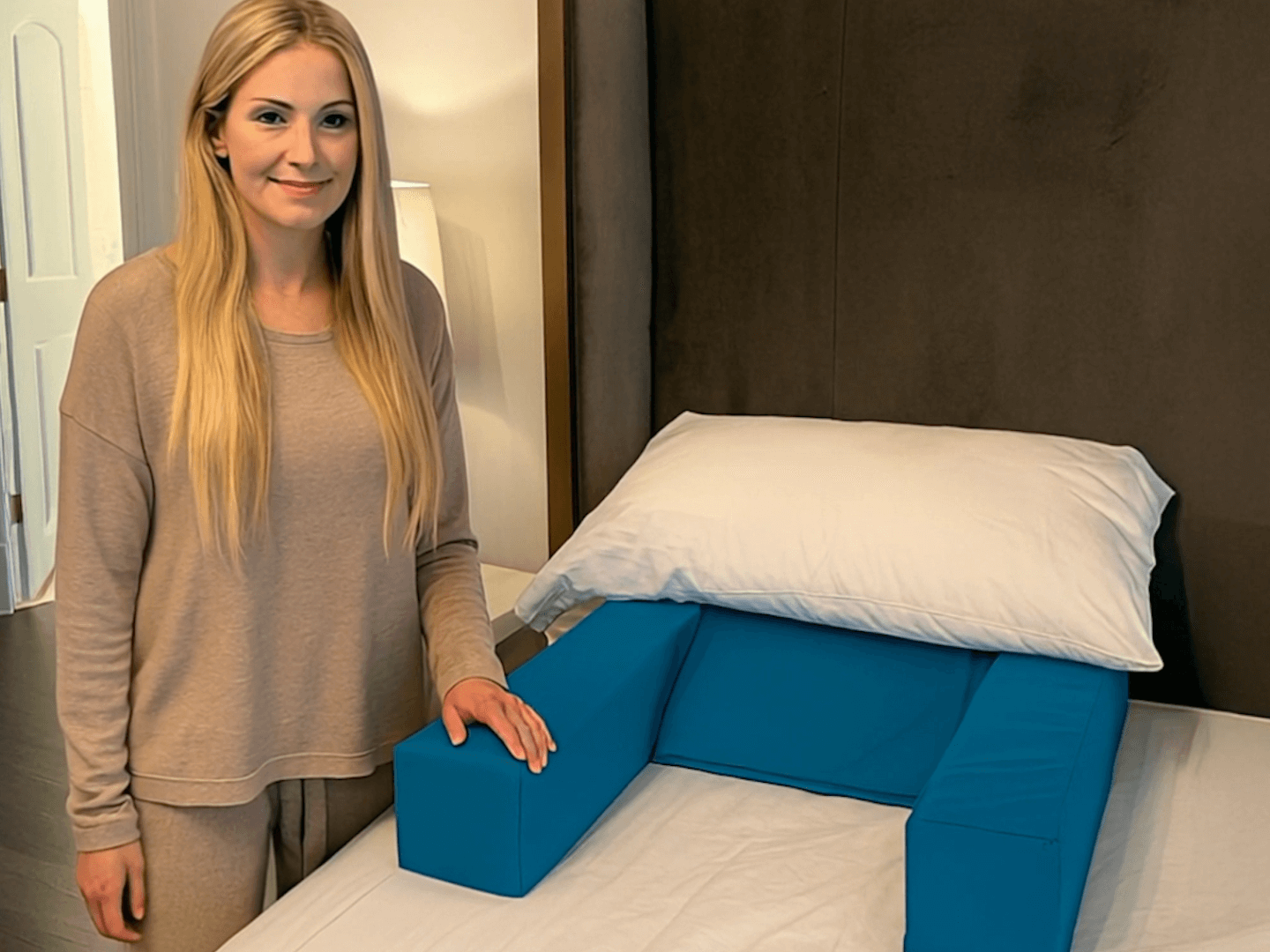 Woman demonstrating Restore You therapeutic sleep apnea support pillow - designed for comfortable sleep in your own bed after surgery.