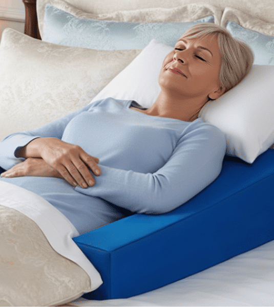 Senior woman sleeping peacefully in her own bed using Restore You therapeutic support for comfortable shoulder surgery recovery at home instead of recliner